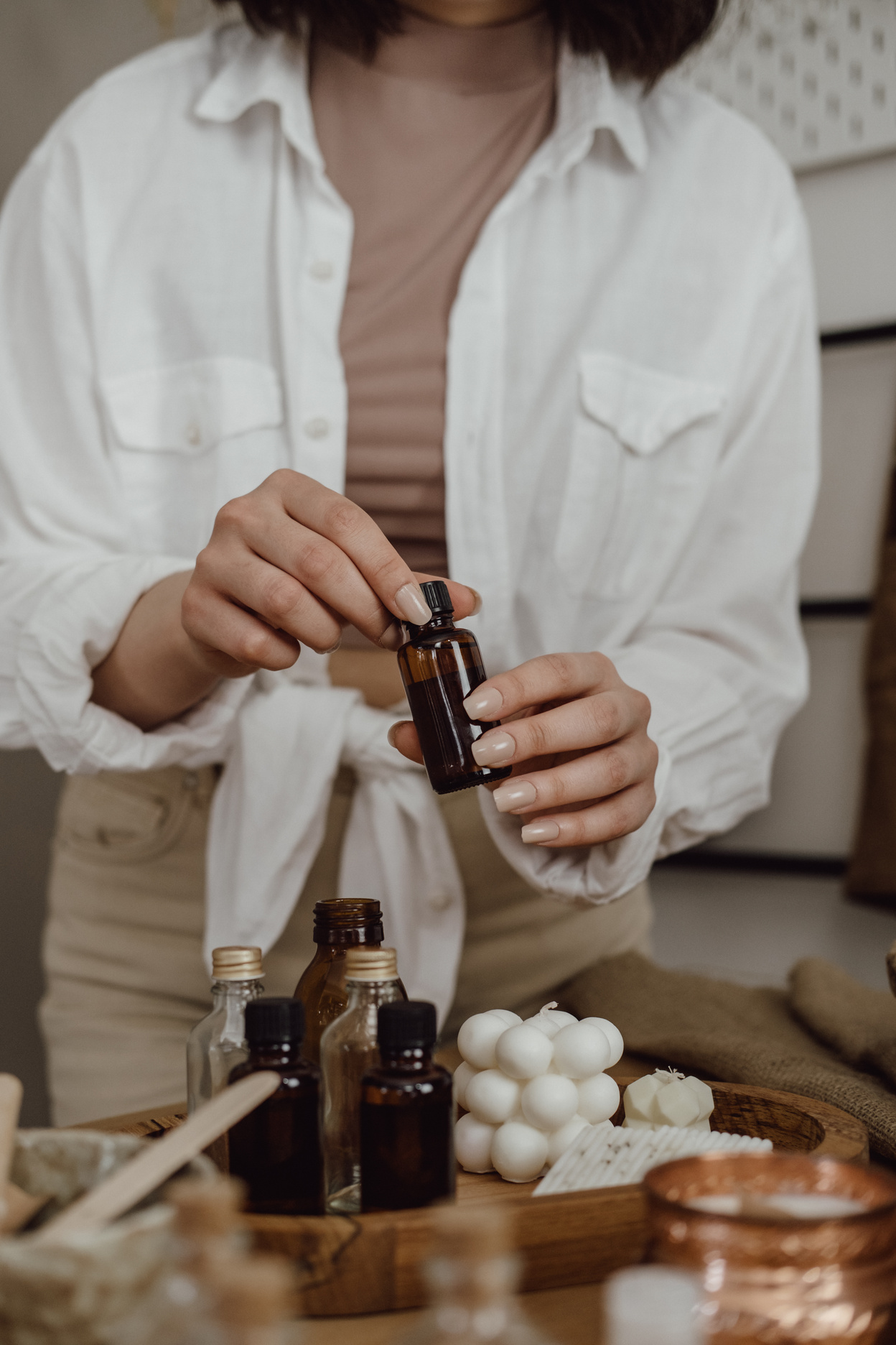Woman Holding a Bottle of Essential Oil for Candle Making