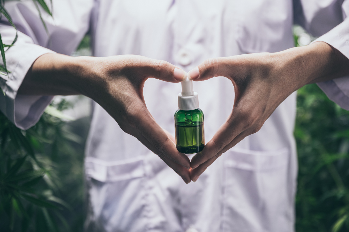 CBD Hemp Oil, Hand Holding Bottle of Cannabis Oil