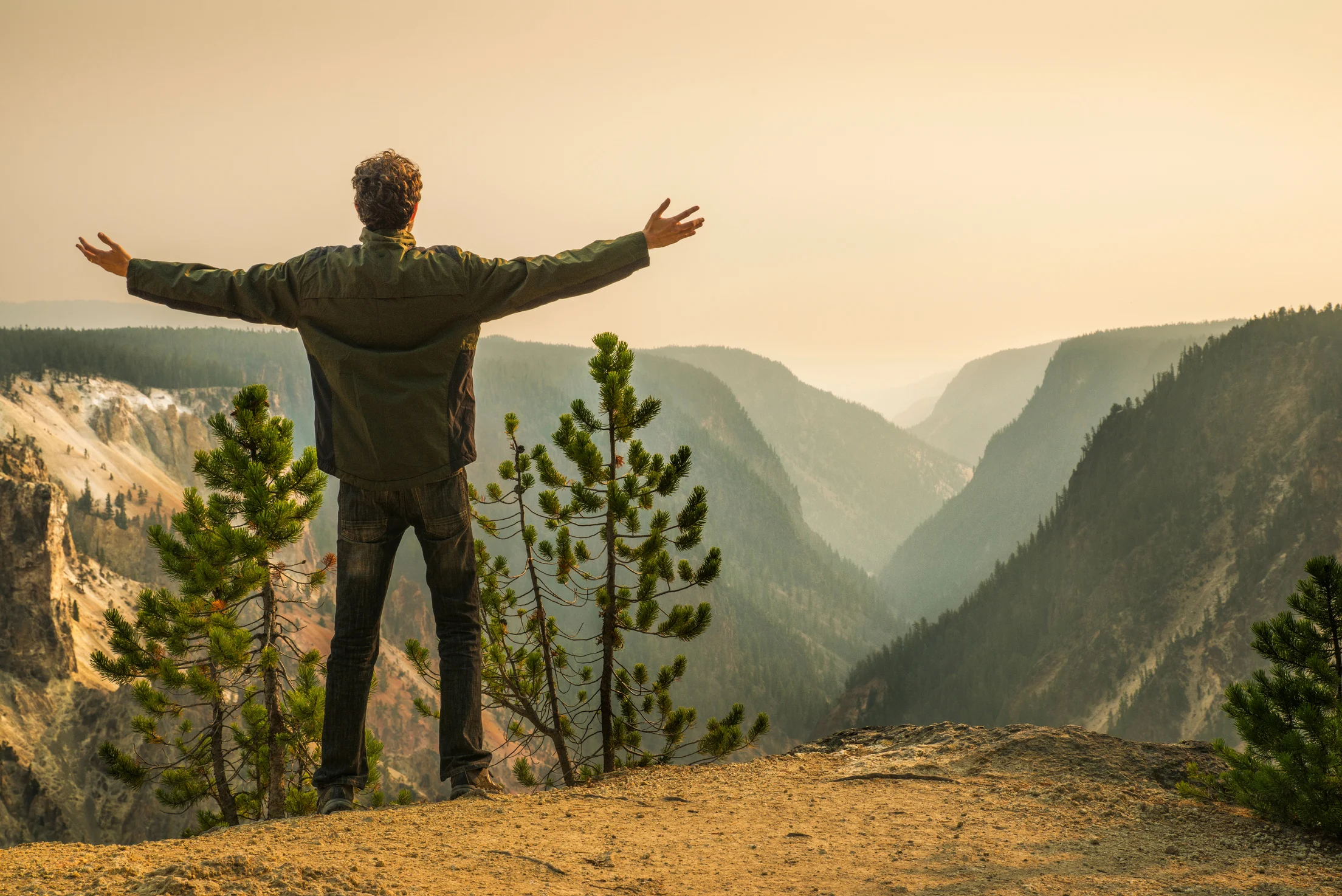 Man open arms Yellowstone canyon