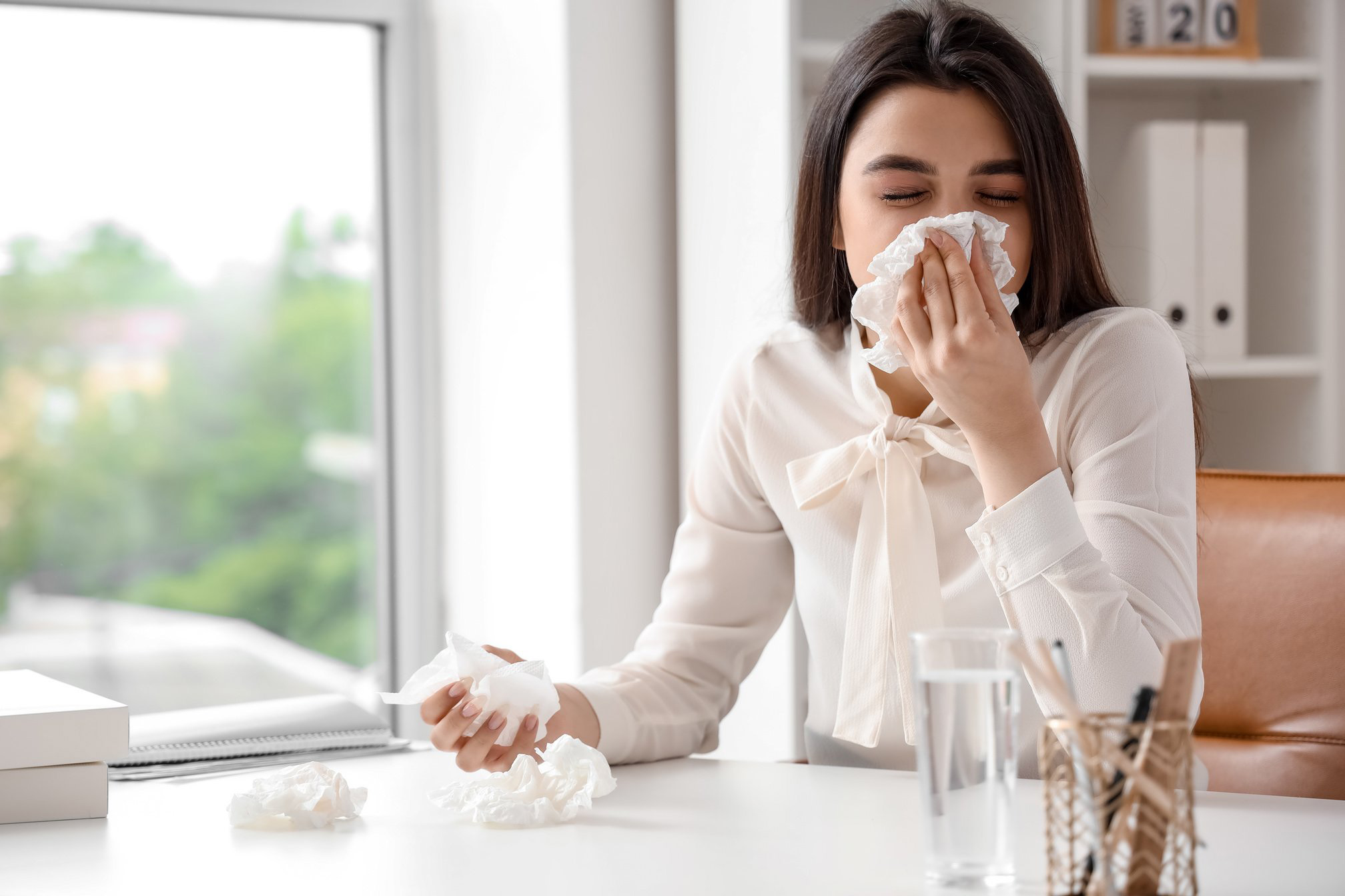 Sick Woman with Runny Nose in Office