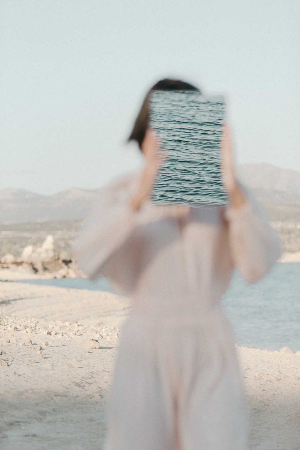 Woman in Sheer Dress with Poster at the Beach